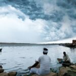 a group of people sitting on rocks in water