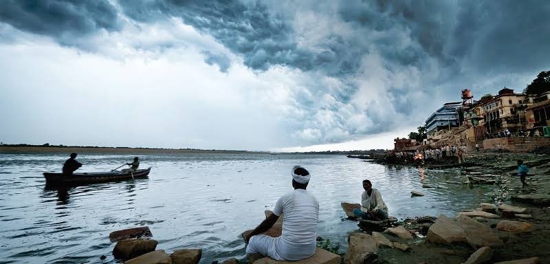 a group of people sitting on rocks in water